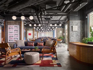 Modern office interior with concrete walls, wooden furniture, and industrial design elements.