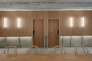 An office space featuring minimalist wooden paneling walls and tables.