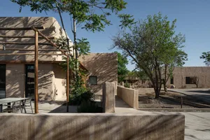 A modern residential yard featuring a concrete structure with a wooden pergola.