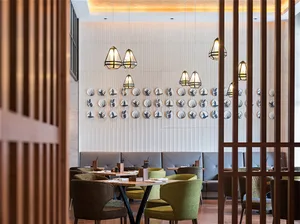 Modern restaurant interior featuring wooden accents, leather seating, and ceramic wall decor