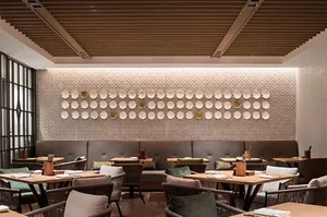 Well-designed, modern restaurant interior with wooden accents, leather seating, and fabric cushions on the chairs and sofas.