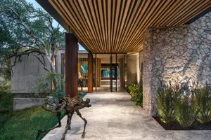 Modern, rustic entryway featuring stone, wood, and concrete materials.