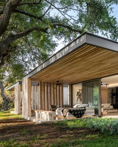 A modern residential patio featuring wood, glass, and concrete materials.