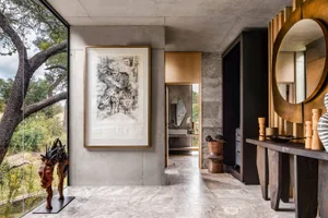 Modern interior space featuring industrial design elements with concrete walls and floors, large windows, and minimalist furn