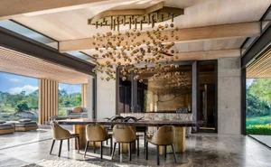 A modern dining room featuring glass, laminate, and concrete materials, with a botanical setting.
