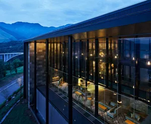 Contemporary residential interior with glass walls and lighting features.