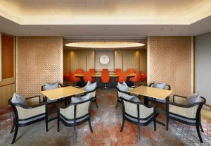 A well-decorated conference room with wooden tables and orange chairs.