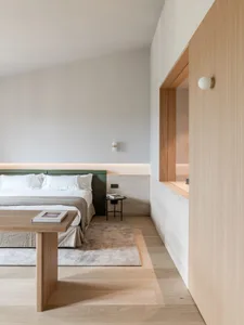 Minimalist bedroom featuring wood and concrete materials