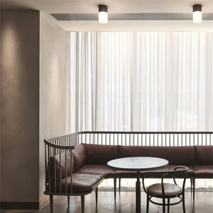 A modern cafe interior designed with leather upholstery and wooden accents, featuring a round table and chairs, large windows