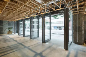 Modern interior with glass doors, concrete floor, and steel structure.