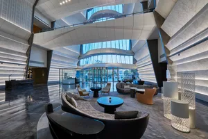 A modern lobby with marble floors, concrete walls, and contemporary furniture.