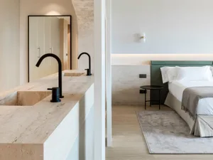 A minimalist modern bedroom with marble and concrete finishes.