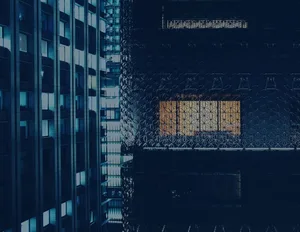 A modern office building with glass windows reflecting a cityscape.