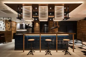 A modern restaurant bar with wood, leather, and metal decor.