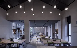 A modern restaurant interior with concrete walls and hanging lights.