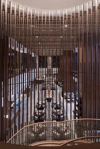 A modern restaurant interior with a mix of walnut and glass materials, featuring a central spiral staircase and a spacious di