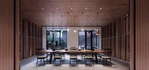 A modern restaurant interior with wooden floors, glass windows, and metal accents.