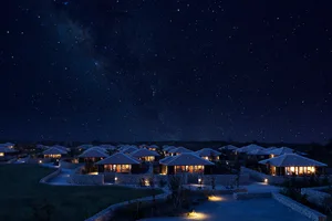A serene night view of residential buildings with stone walls and glass windows.