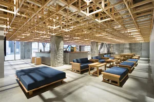 A café interior with wooden furniture and an exposed wooden lattice ceiling.