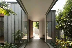 A minimalist entrance with glass panels and a wooden door.