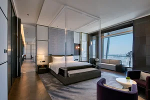 A modern hotel suite featuring glass and steel materials, designed to provide a luxurious and contemporary experience.