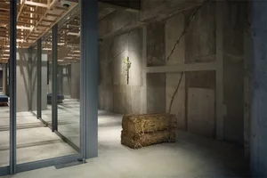 Concrete walls and floor with hay bales in an office space.