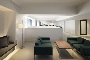 A modern office interior featuring a minimalist design with a concrete wall and floor.