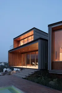 Modern residential exterior with wood, glass, and concrete materials.