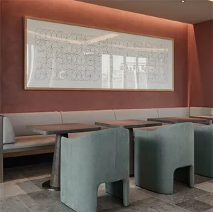 A modern restaurant interior featuring concrete furniture and a geometric wall art piece.