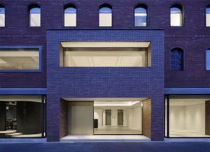 Modern retail storefront with brick facade illuminated at dusk.
