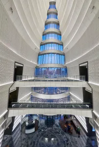 Modern skyscraper interior featuring glass walls, polished concrete floors, and steel structural elements with dynamic lighti
