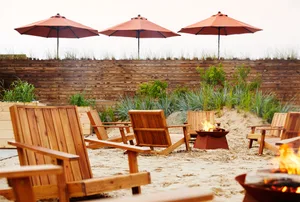Outdoor lounge area with wooden chairs and umbrellas
