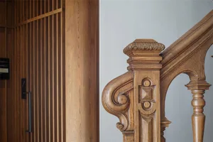 A detailed wooden staircase with ornate carvings and a wooden wall.