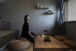 A woman sitting at a wooden table in a modern coffee shop interior