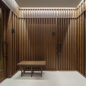 A spacious spa interior with tall, wooden paneled walls, a white floor, and ceiling with integrated lighting.