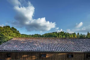 A close-up view of a traditional roof featuring overlapping terracotta tiles.