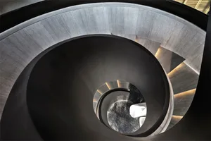 Spiral staircase made of concrete with a circular design.