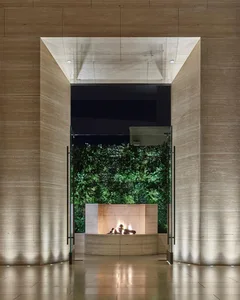 A minimalist lobby features sandstone walls and LED lights.