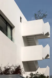 Modern building exterior with concrete facade and spiral staircase.
