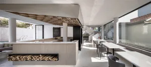 Modern espresso bar with concrete counter, glass shelves, and contemporary furniture.