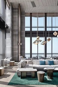 Modern hotel lobby featuring concrete, glass, and metal materials.