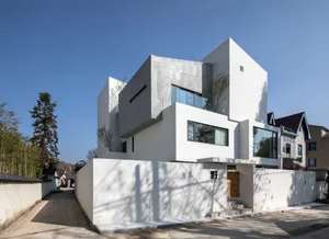 Modern, minimalist house exterior featuring concrete, glass, and aluminum materials.
