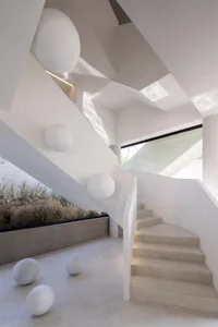 Modern room with concrete floor, glass walls, and geometric shapes.