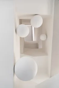 Modern minimalist interior with white walls and spherical light fixtures.