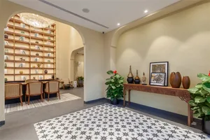 A modern lobby featuring solid hardwood floors and concrete accents, adorned with potted plants and decorative items.