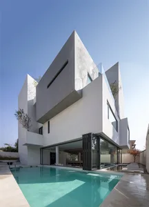 A modern residential exterior features a concrete house with a swimming pool.