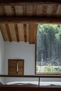 簡約臥室以木質與竹材元素為主，大型窗戶框出自然光景。