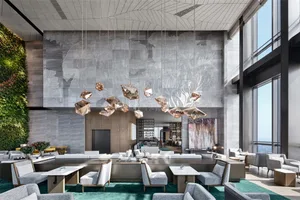 Modern hotel lobby interior with concrete wall, glass pendant lights, and contemporary furniture.