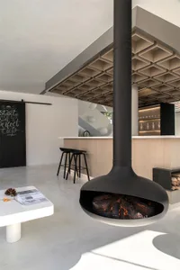 A modern kitchen and bar area with concrete and light wood finishes