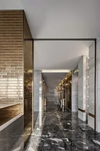 A modern corridor with marble flooring and brick walls.